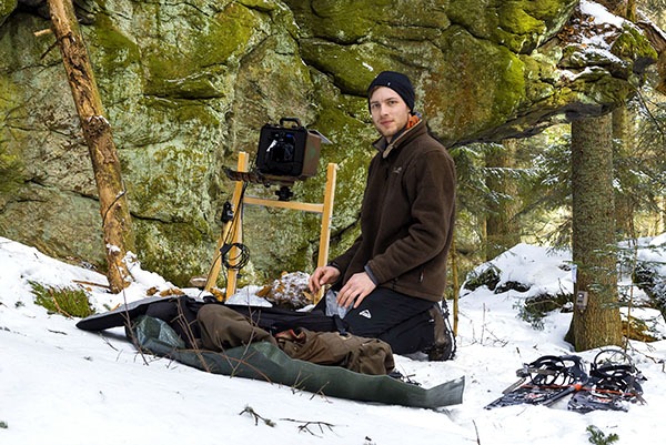 Julius Kramer (Bild: Wolfgang Lorenz) Der Naturfotograf Julius Kramer installiert eine Kamerafalle an einem Felsen.